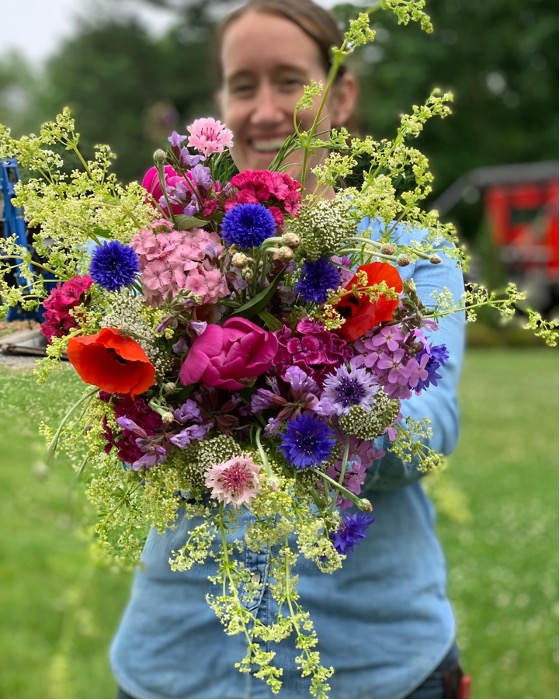 Becca Toms behind a bouquet of flowers