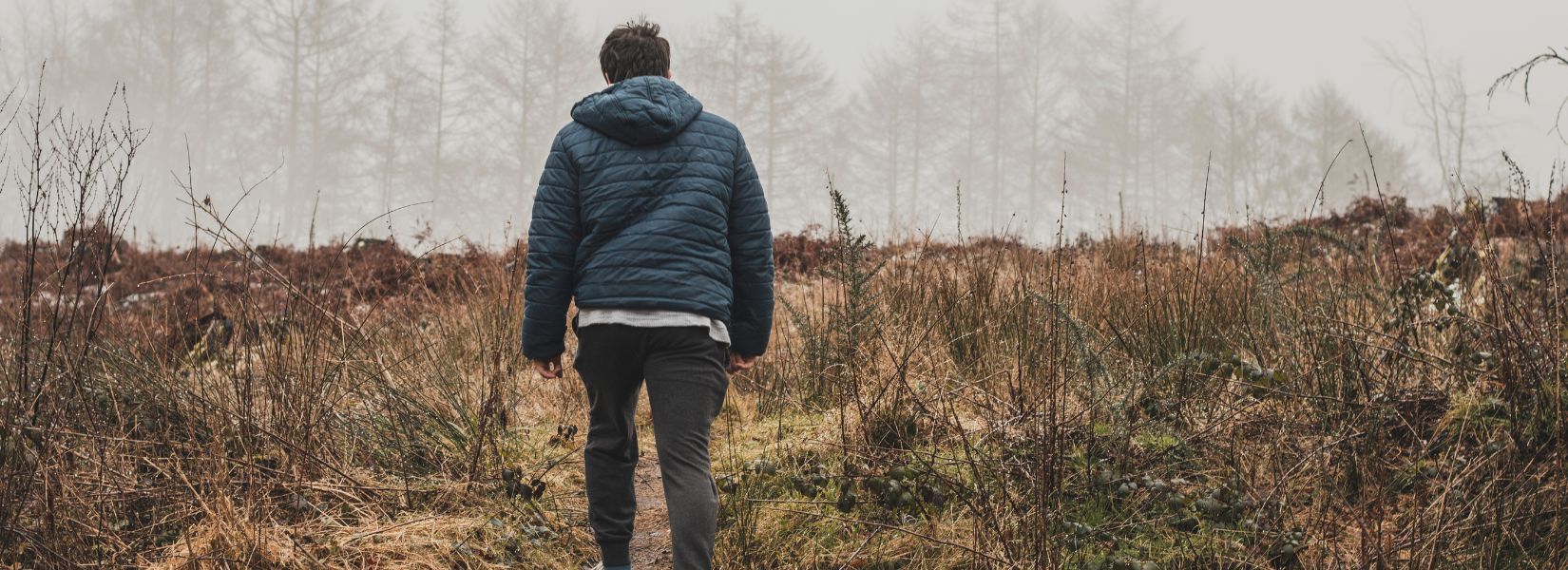 Man walking an overgrown field