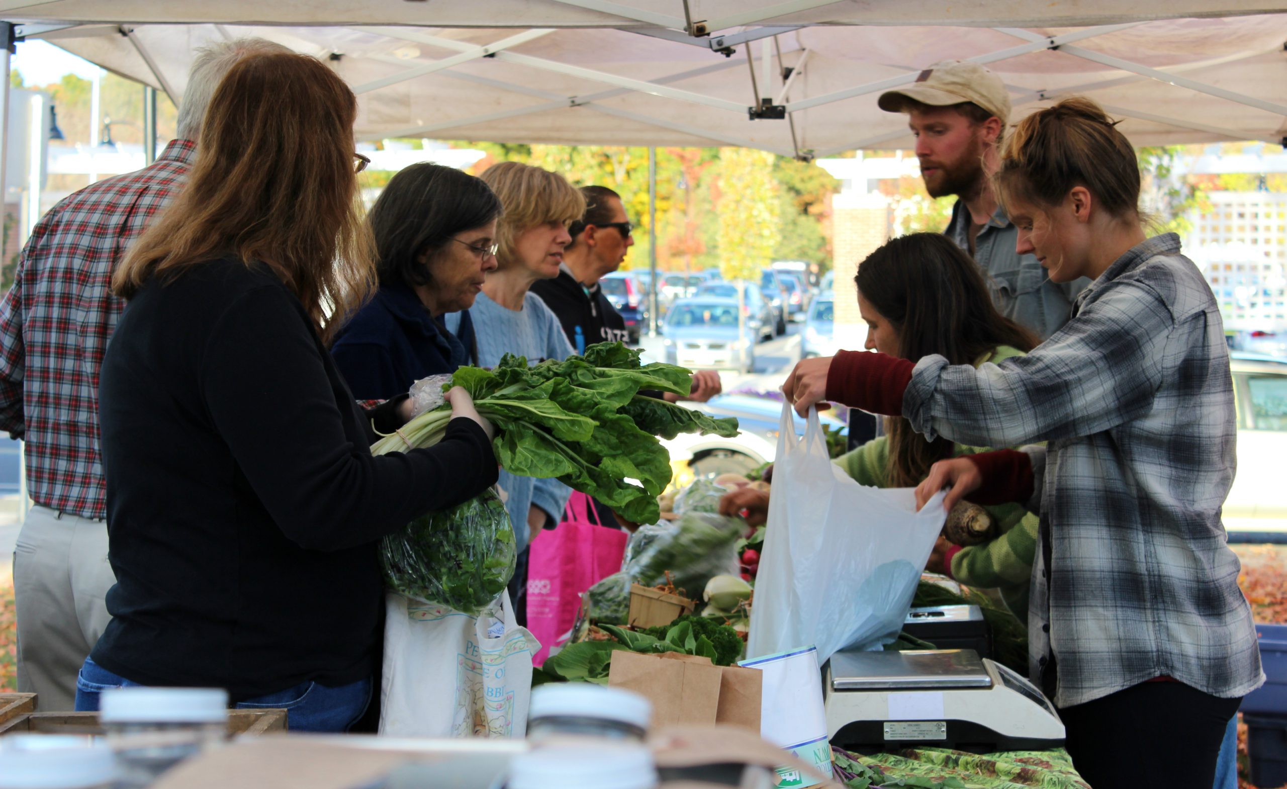 customers and farmers talking over market tables